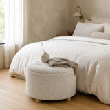 Pouf Flocon bouclette blanc au pied d'un lit